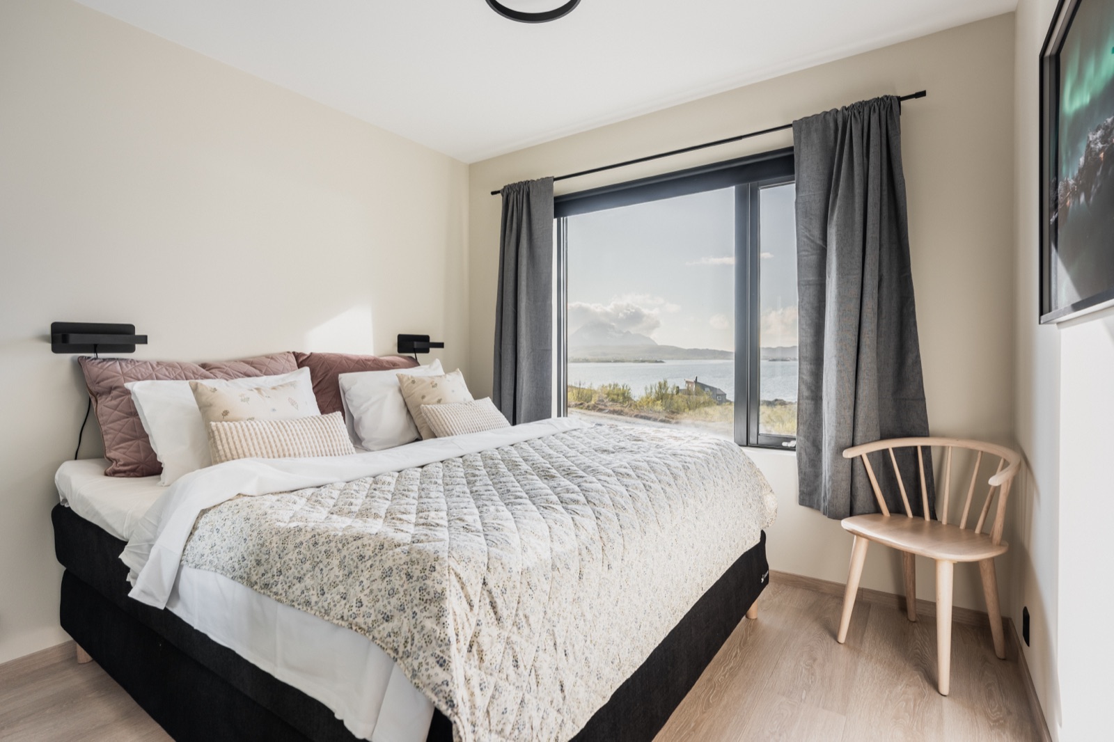 Double bedroom with a large window onto the fjord and the peaks