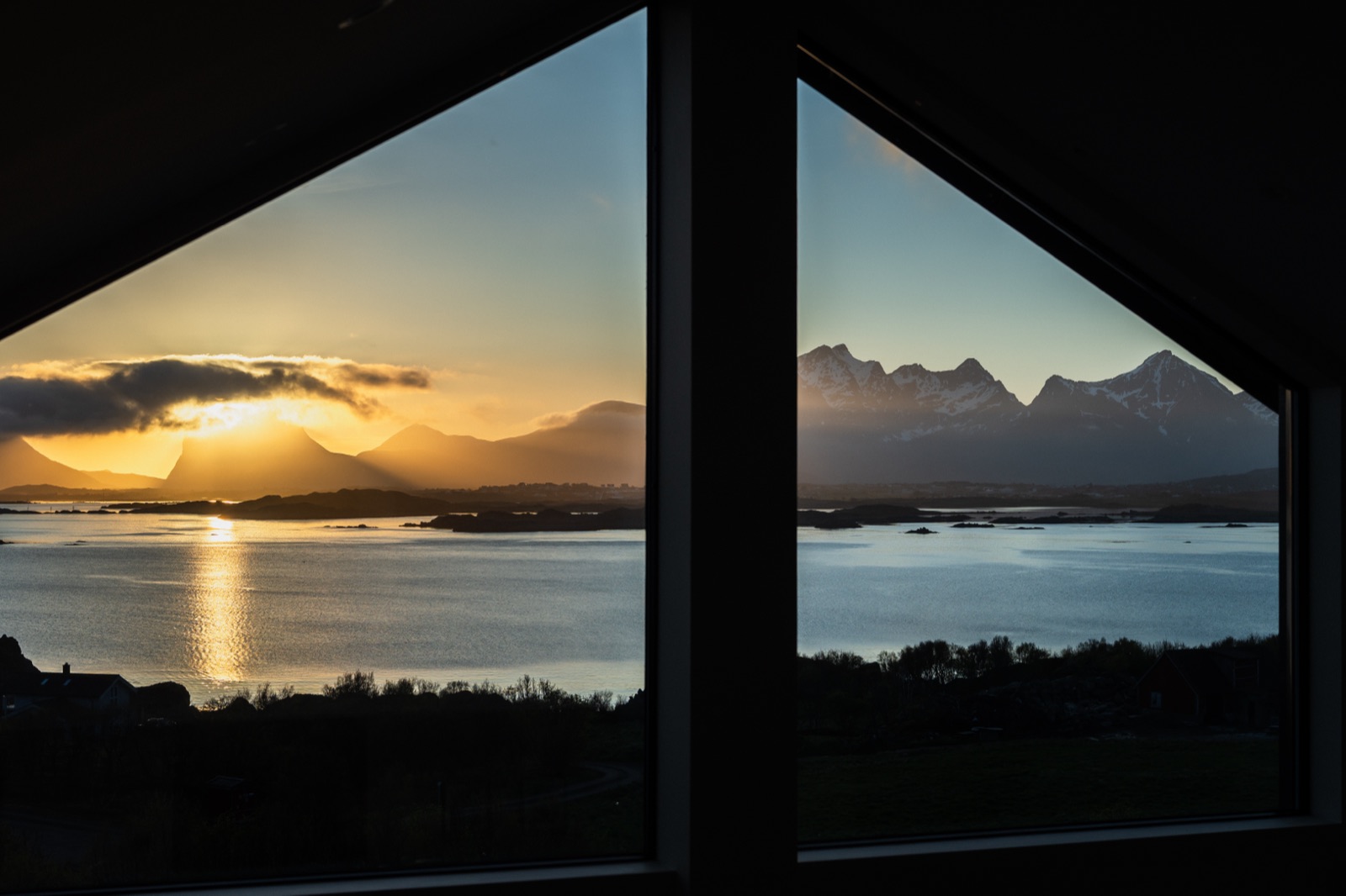 Sunset and snow-capped peaks seen through the triangular gable windows