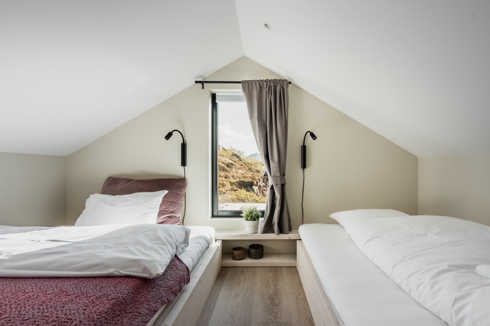 Attic room with two large single beds under the gable window